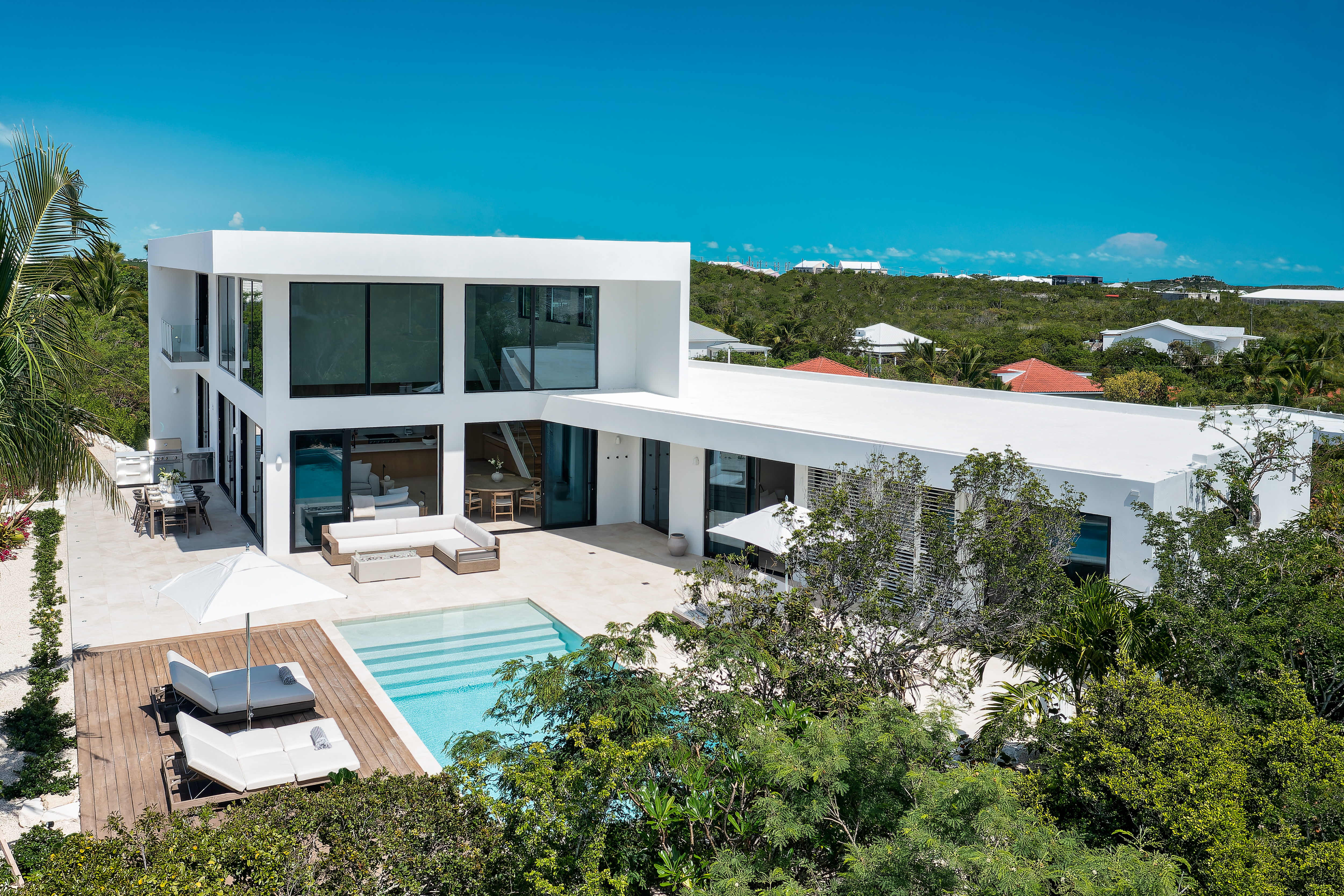 Aerial view of Beachwood Villa, its pool and terrace above the north shore of Providenciales