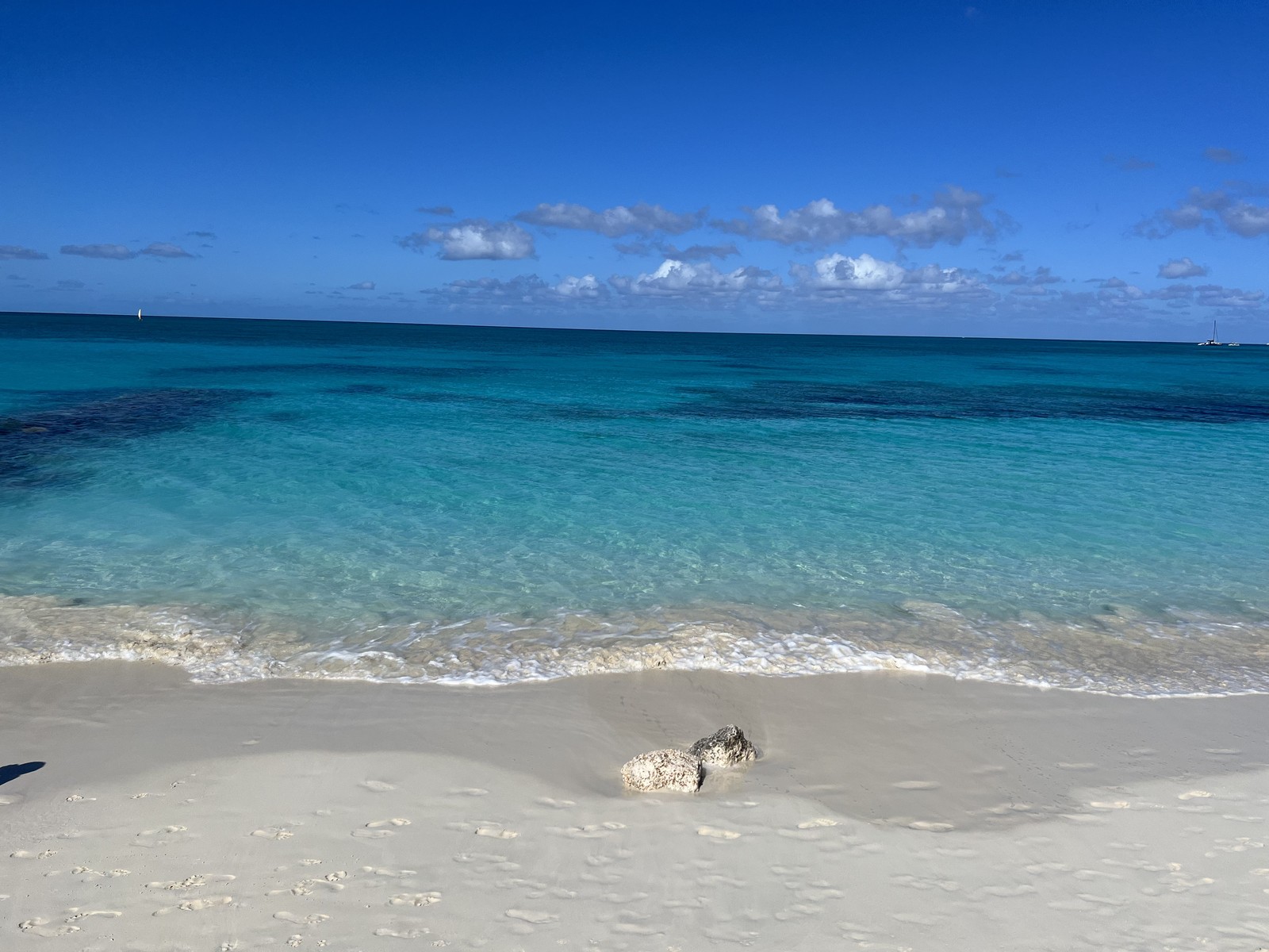The quiet curving bay, calm water and wide empty sand at Leeward Beach, the secluded eastern end of Grace Bay, Providenciales Turks and Caicos