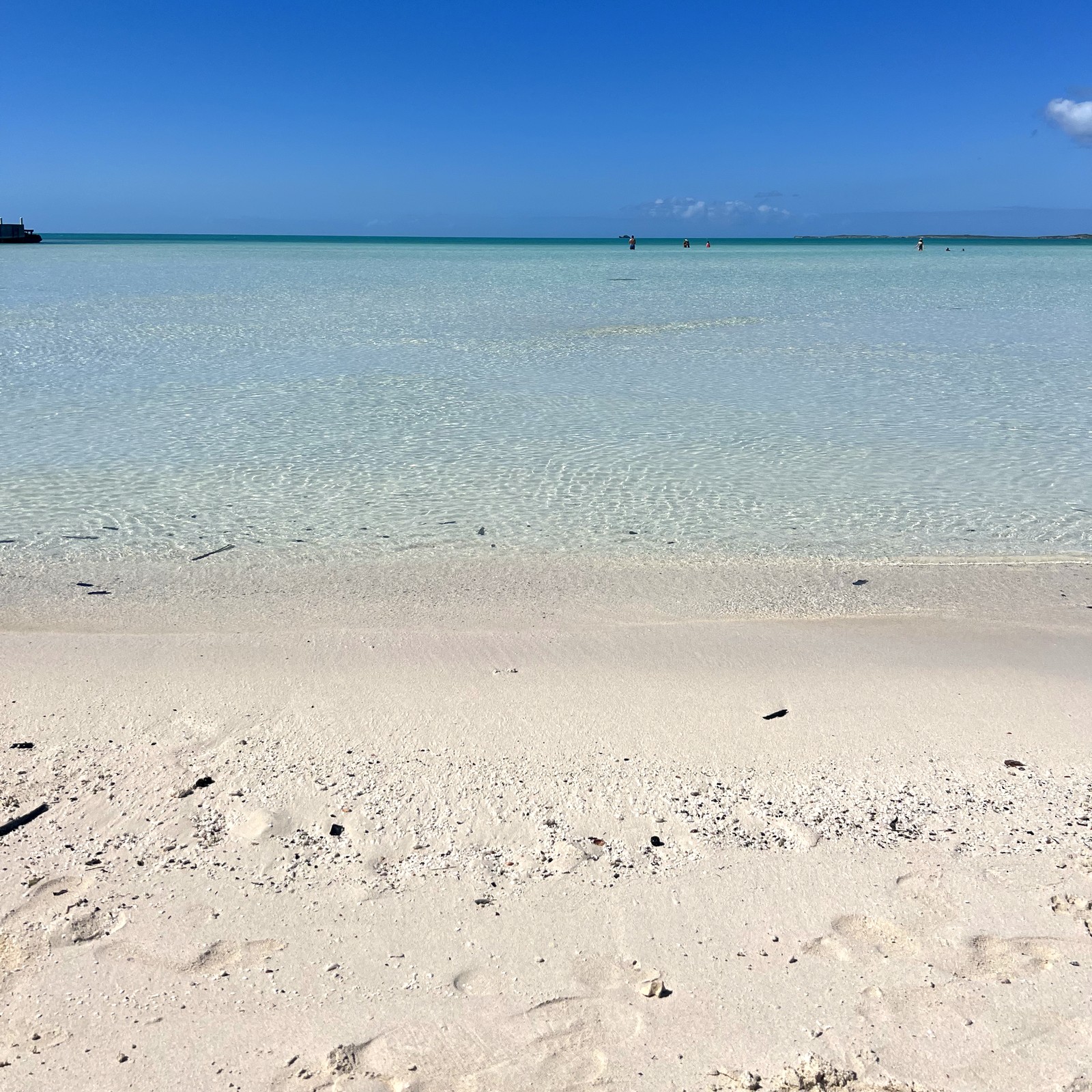 The calm shallow turquoise water and white sand of Taylor Bay, where the water stays knee-deep far from shore, Providenciales Turks and Caicos
