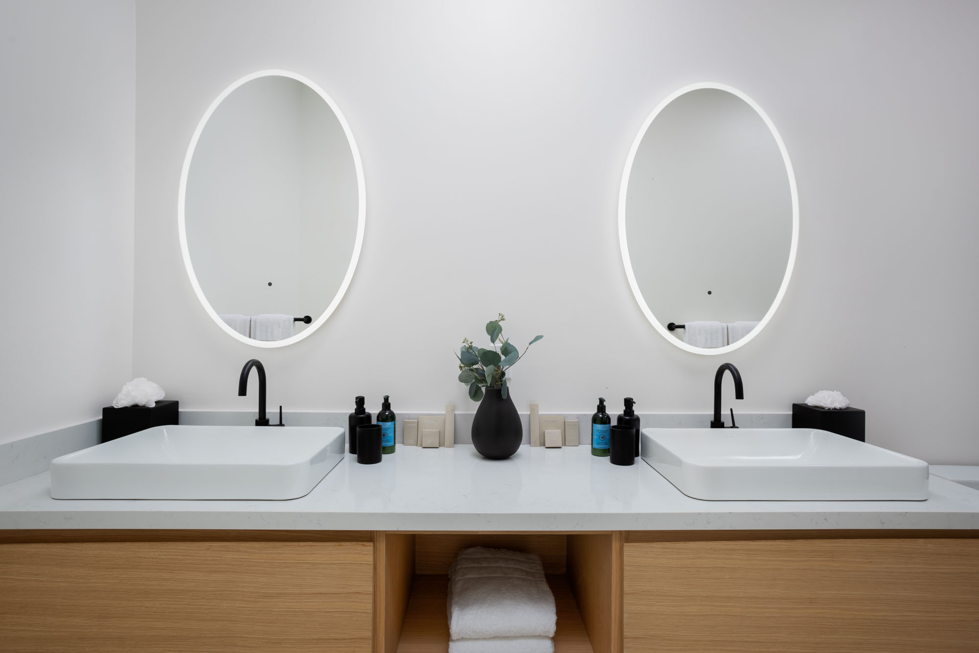 Pool Suite ensuite with twin oval mirrors, vessel sinks, matte black fixtures, and floating oak vanity