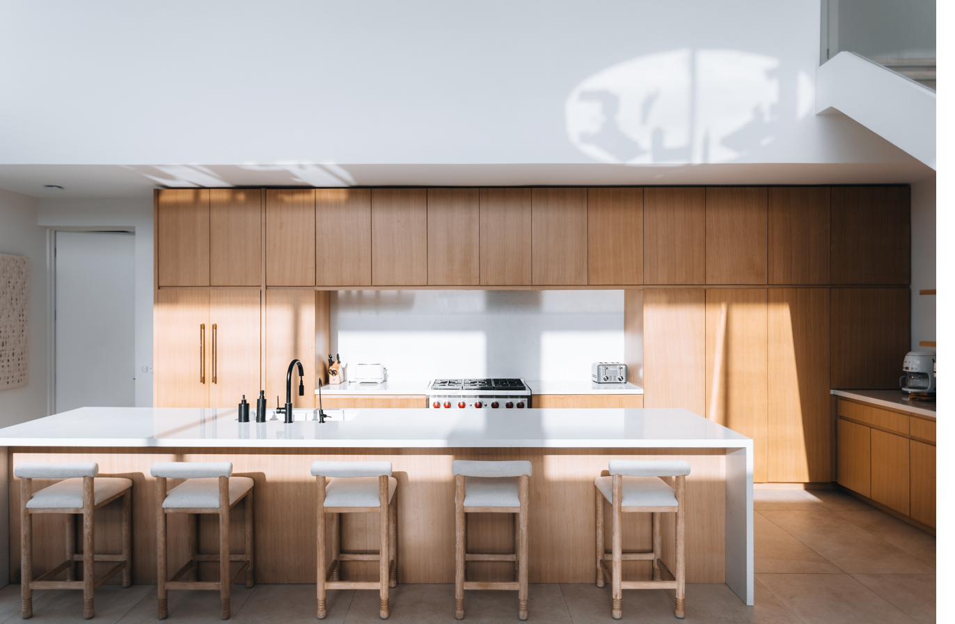Beachwood Villa kitchen with Wolf professional range, white quartz countertops, fourteen-foot island, custom oak cabinetry, and five barstools in Providenciales Turks and Caicos