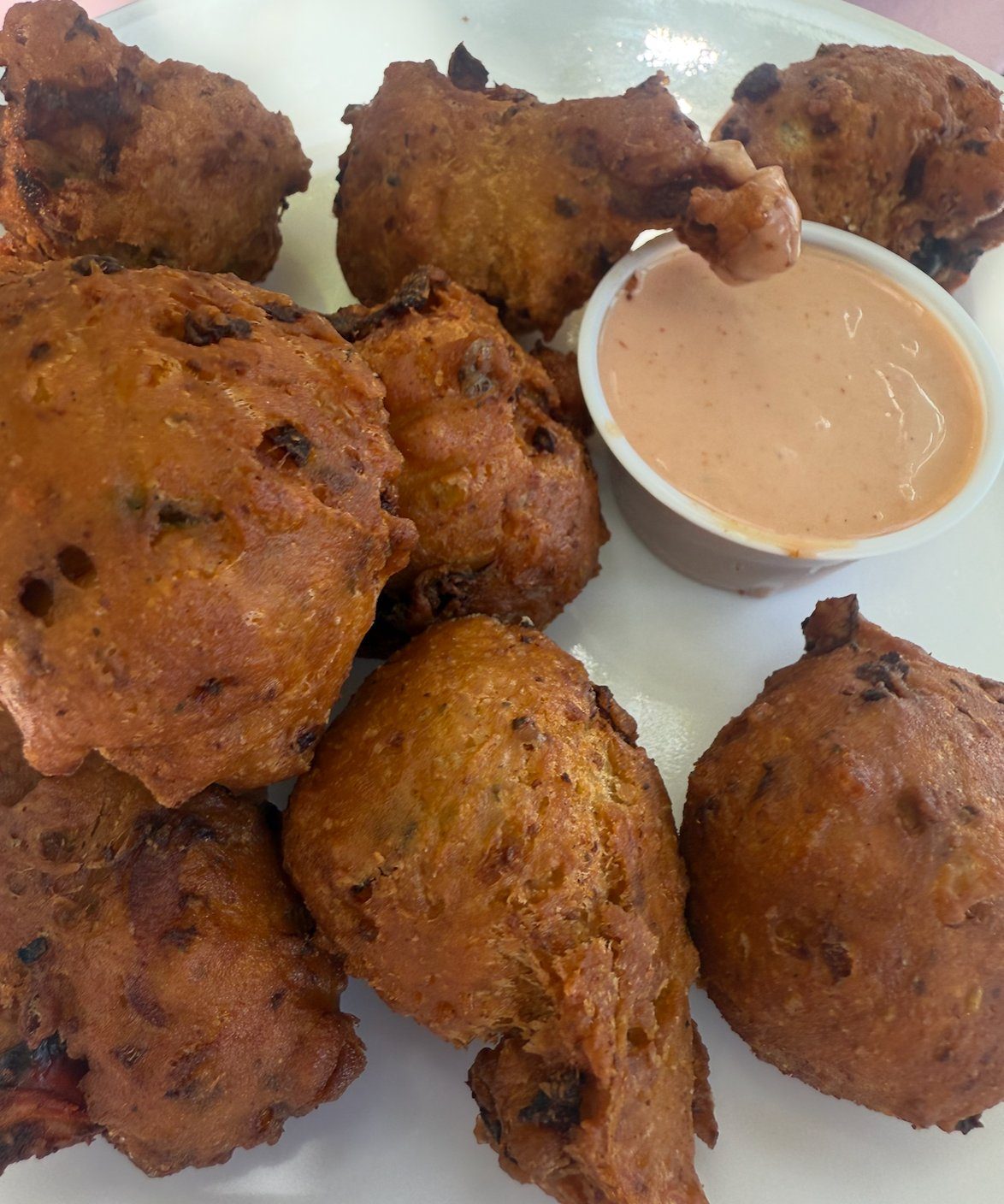 A plate of golden conch fritters with dipping sauce at da Conch Shack, Providenciales Turks and Caicos