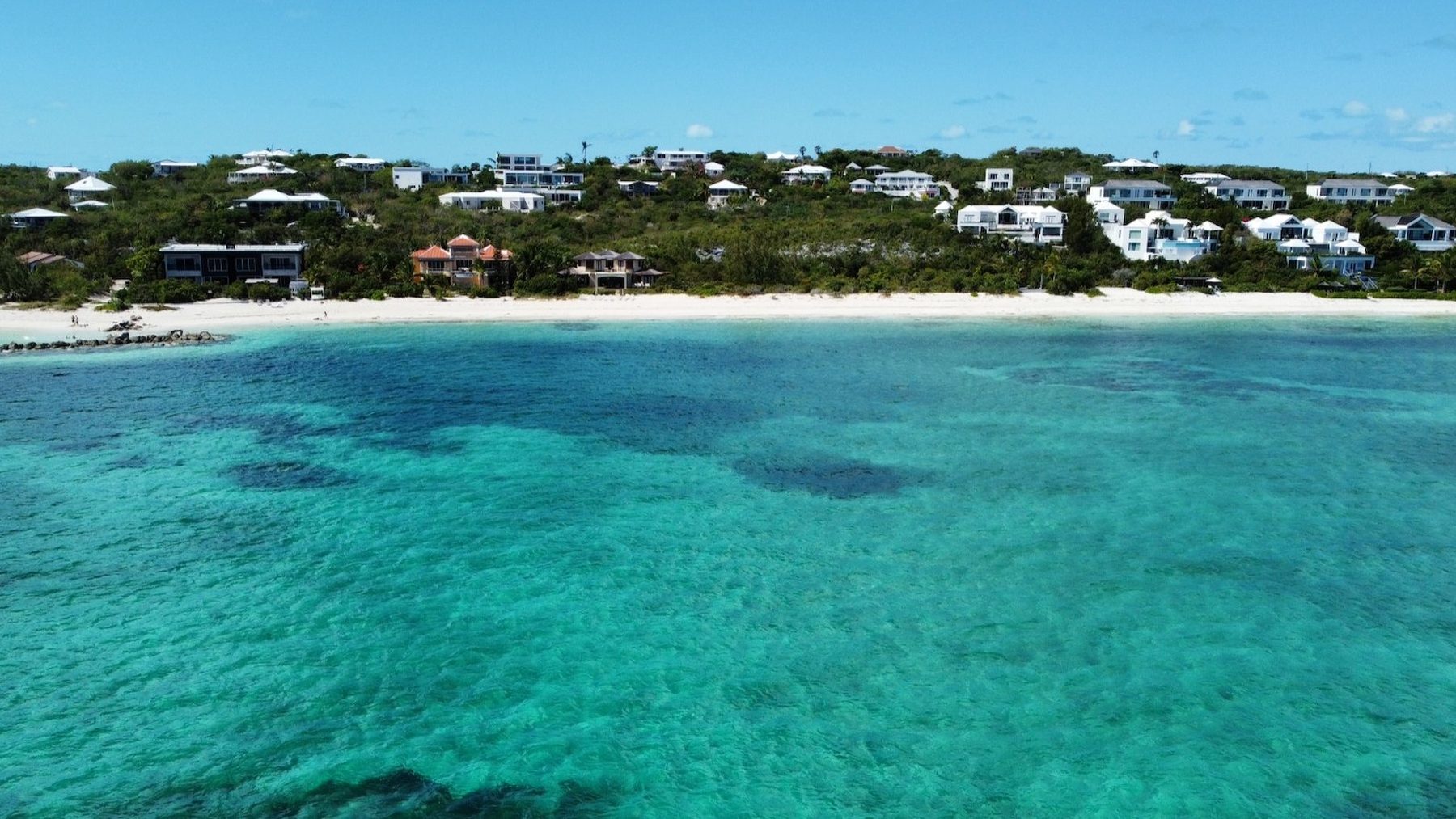 An elevated view over the quiet turquoise water and white sand of the North Shore near Turtle Cove, Providenciales, Turks and Caicos
