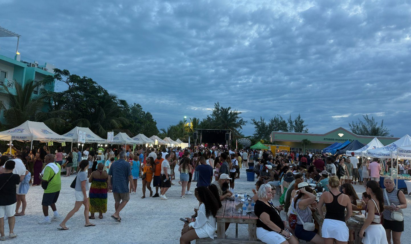 Crowds, food stalls, picnic tables and a live-music stage at dusk at the Thursday Fish Fry, Stubbs Diamond Plaza, the Bight, Providenciales