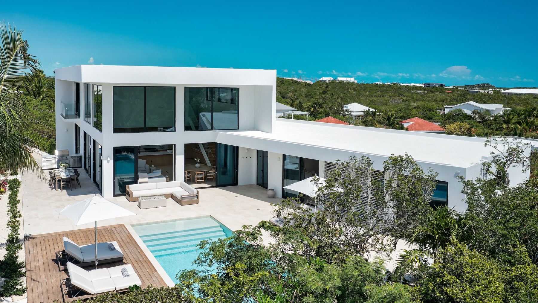 The living areas and pool of a private villa with high ceilings and ocean views in Providenciales, Turks and Caicos