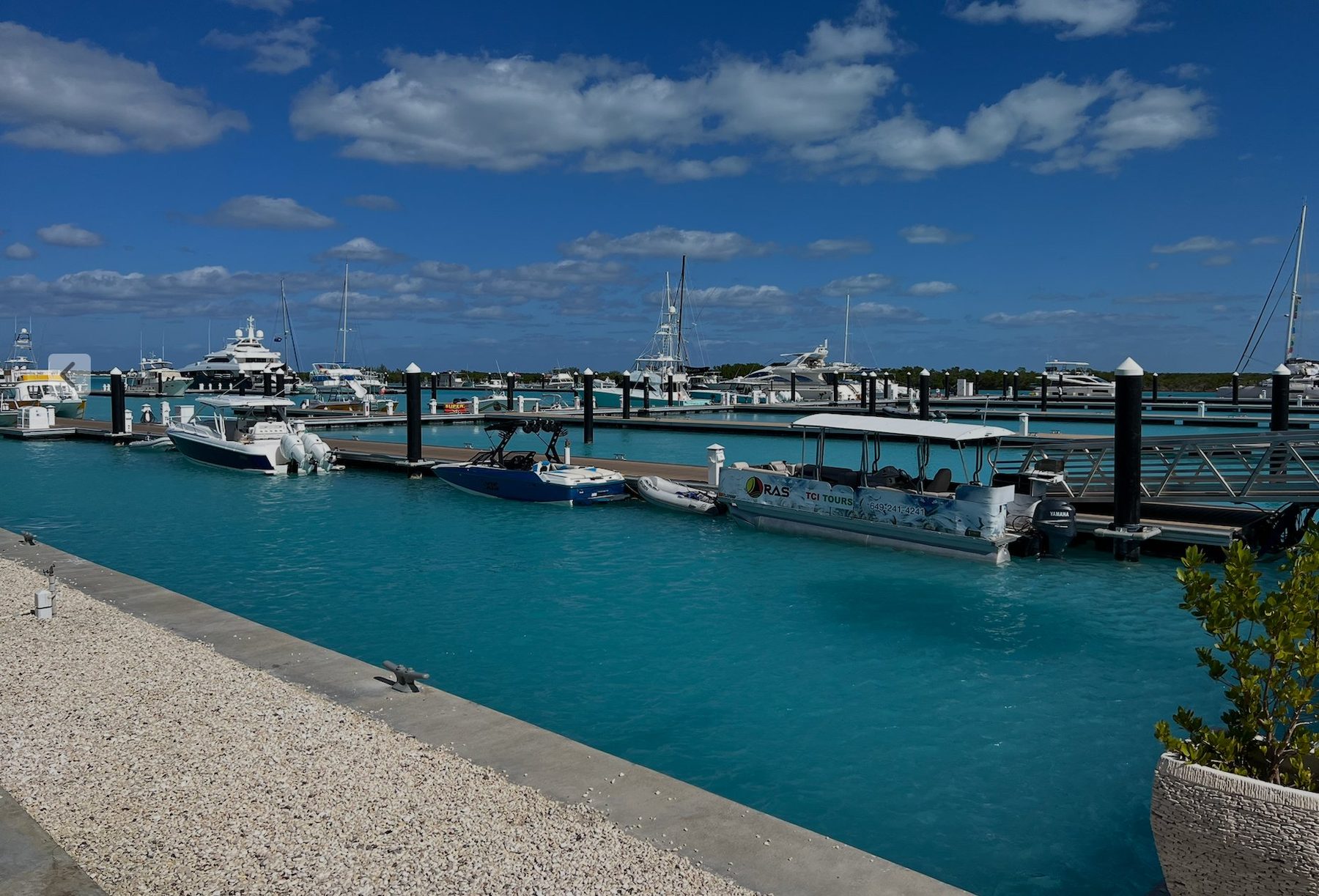 Charter boats, sportfishing boats, and tour vessels moored at a marina in Providenciales, Turks and Caicos